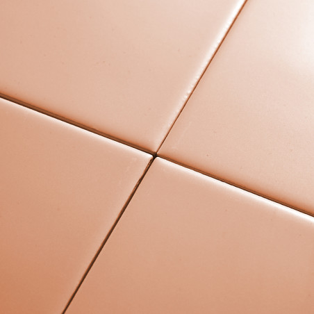 Four smooth, peach-colored ceramic tiles are aligned neatly, forming a grid pattern with visible grout lines in between.
