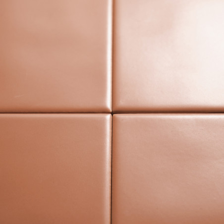 Vier gladde, beige tegels kruisen elkaar en vormen een kruispatroon. het oppervlak is glanzend, wat duidt op een schone binnenom