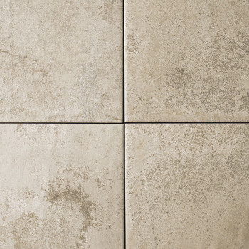Quatre carreaux de pierre beige disposés en carré, présentant des taches subtiles et des motifs marbrés, créent un aspect nature