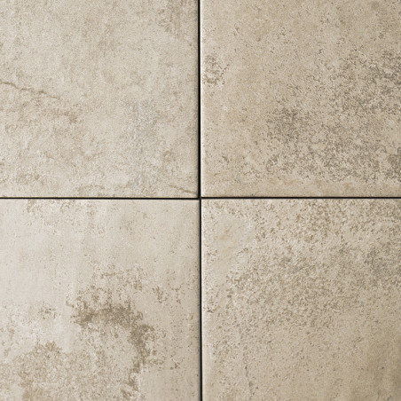 Quatre carreaux de pierre beige disposés en carré, présentant des taches subtiles et des motifs marbrés, créent un aspect nature
