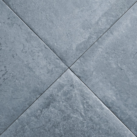 Quatre carreaux gris foncé forment un motif en X avec des marbrures subtiles, créant une surface texturée dans un cadre neutre e