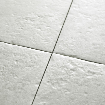 Les carreaux de céramique texturés de couleur claire s'assemblent parfaitement selon un motif en grille, formant une surface de 