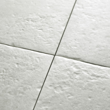 O revestimento cerâmico texturizado de cor clara se une perfeitamente em um padrão de grade, formando uma superfície de piso lis O revestimento cerâmico texturizado de cor clara se une perfeitamente em um padrão de grade, formando uma superfície de piso lis