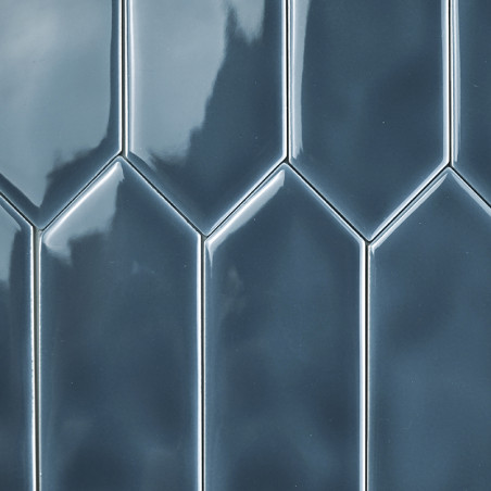 Glänzende, blaue Fliesen bilden vertikal angeordnet ein gestaffeltes, geometrisches Muster. Die Oberfläche reflektiert das Licht Glänzende, blaue Fliesen bilden vertikal angeordnet ein gestaffeltes, geometrisches Muster. Die Oberfläche reflektiert das Licht