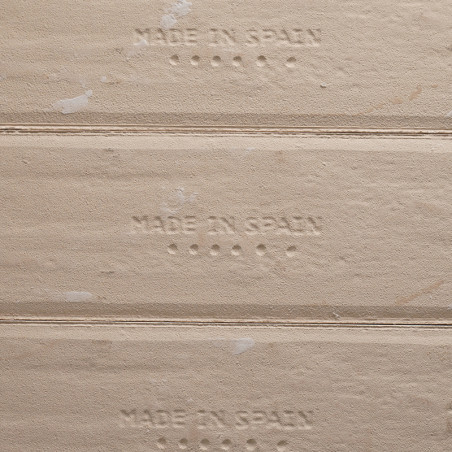De tekst in reliëf `MADE IN SPAIN` verschijnt op beige tegelranden, met kleine stippen onder elke zin, die de oorsprong van de p De tekst in reliëf `MADE IN SPAIN` verschijnt op beige tegelranden, met kleine stippen onder elke zin, die de oorsprong van de p