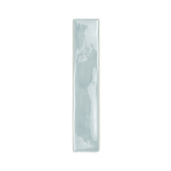 Een lange, rechthoekige keramische tegel is geglazuurd in een glanzende, lichtblauwe kleur en reflecteert licht. Het rust tegen 