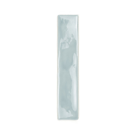 Um longo ladrilho cerâmico retangular é esmaltado em uma cor azul claro brilhante, refletindo a luz. Ele repousa sobre um fundo 