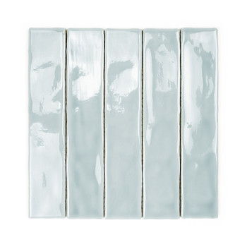 Un long carreau de céramique rectangulaire est émaillé d’une couleur bleu pâle brillante, réfléchissant la lumière. Il repose su