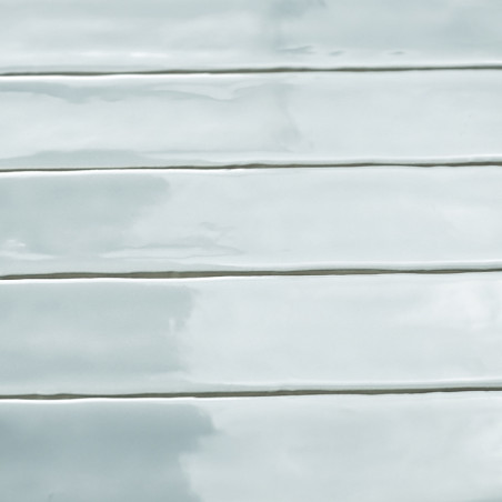 Ladrilhos brilhantes, retangulares e verdes claros são alinhados horizontalmente, criando uma superfície elegante e reflexiva co