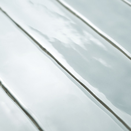 Ladrilhos retangulares alongados e brilhantes refletem a luz, criando sombras suaves. posicionados de perto, eles formam uma sup