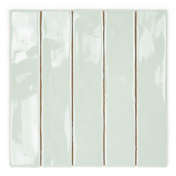 Un long et étroit carreau de céramique vert pâle brillant repose sur un fond blanc uni, mettant en valeur sa surface lisse et ré