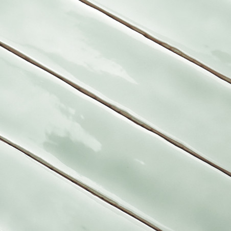 Les carreaux rectangulaires vert clair brillants sont alignés avec des lignes de coulis étroites et plus foncées, créant une app Les carreaux rectangulaires vert clair brillants sont alignés avec des lignes de coulis étroites et plus foncées, créant une app