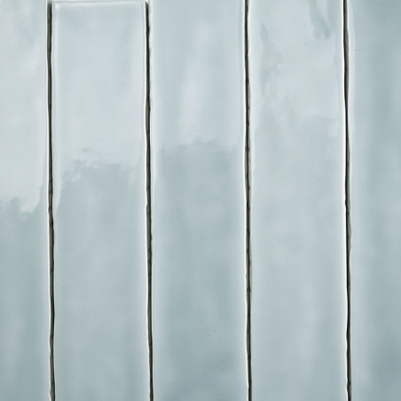 Los azulejos rectangulares se colocan verticalmente en una cuadrícula, con un acabado gris pálido brillante, que refleja la luz 