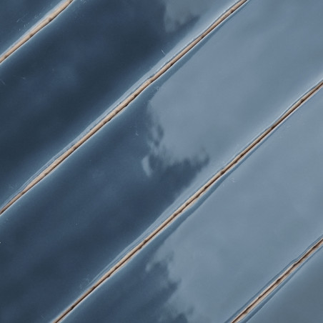 Diagonal ausgerichtete blaue Keramikfliesen mit glänzender Oberfläche, die Licht reflektieren und durch dünne, helle Fugenlinien