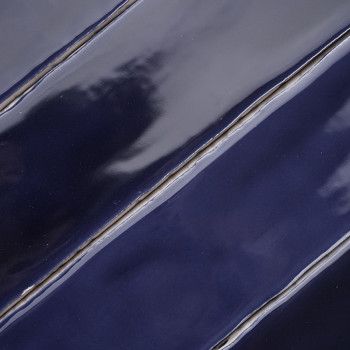 Azulejos de color azul oscuro brillante con reflejos sutiles, estructurados en diagonal, creando una estética elegante y moderna