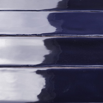 Los azulejos de cerámica de color azul intenso y brillante reflejan la luz, creando un patrón brillante en forma de ondas. Los m