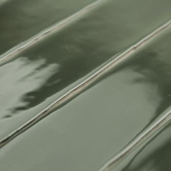 Les carreaux verts rectangulaires brillants sont étroitement alignés, affichant une subtile texture ondulée. Ils réfléchissent l