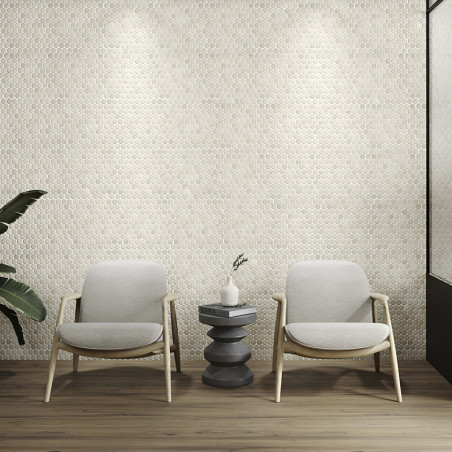 Elegantes Azulejos de piedra hexagonales forman una pared texturizada, iluminada por focos, detrás de dos sillas y una mesa.
