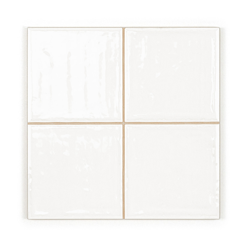 Quatre carreaux carrés blancs brillants sont disposés dans une grille 2x2, affichant une surface uniforme et lisse dans un décor