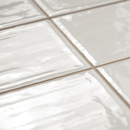 Les carreaux de céramique blanche présentent une surface brillante avec des textures légèrement ondulées, disposées selon un mot Les carreaux de céramique blanche présentent une surface brillante avec des textures légèrement ondulées, disposées selon un mot