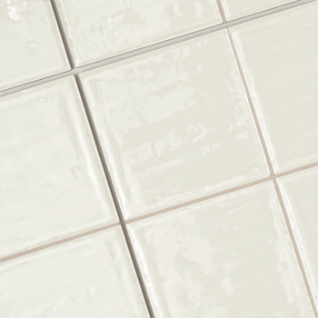 Keramische tegels, gerangschikt in een rasterpatroon, vertonen een glanzend, lichtbeige oppervlak. Ze creëren een strak, gepolij