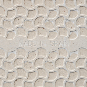 O ladrilho apresenta um padrão semicircular sobreposto e em relevo. `MADE IN SPAIN` inscrito no centro. O fundo é uma cor bege c