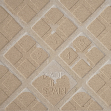 Tan textured tile displays a geometric diamond pattern with numbers 1 to 5 etched inside. The words `MADE IN SPAIN` are embossed