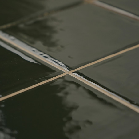 Les carreaux de céramique vert brillant forment un motif quadrillé réfléchissant la lumière. Ils sont parfaitement alignés, créa