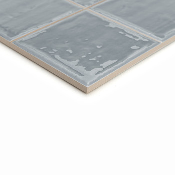 Les carreaux de céramique gris présentent une finition brillante et un motif légèrement irrégulier. Les tuiles sont disposées da