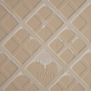Bloco com números em relevo de 1 a 6 em formatos de diamante. O texto `MADE IN SPAIN` é incorporado centralmente no padrão de gr