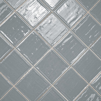 Les carreaux de céramique gris disposés selon un motif de grille diagonale, réfléchissant la lumière, créent un aspect brillant 