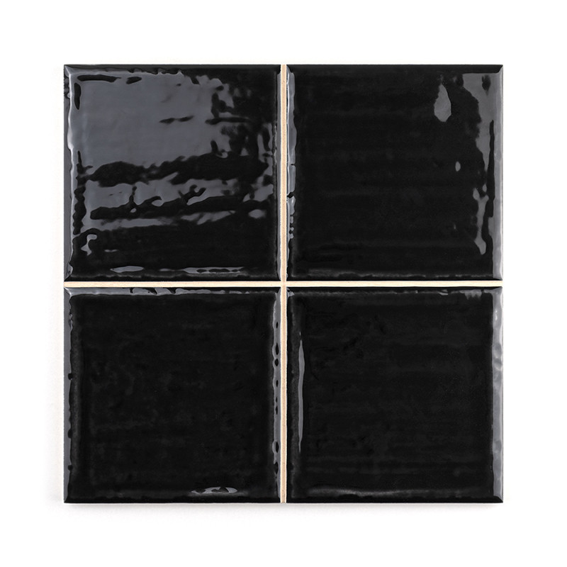 Vier schwarz glänzende Keramikfliesen sind quadratisch angeordnet. Jede Fliese reflektiert Licht und erzeugt subtile Variationen