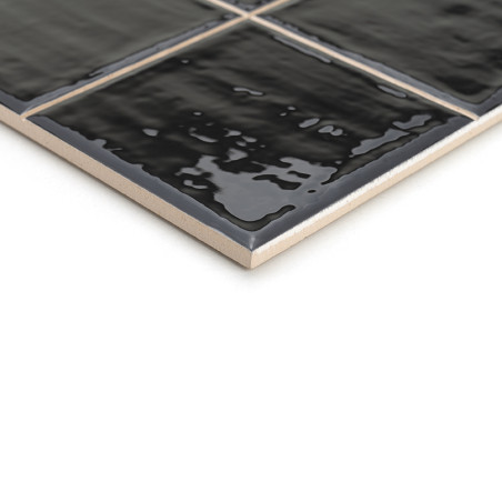 Um ladrilho cerâmico preto brilhante apresenta uma superfície texturizada, refletindo a luz sutilmente. Encontra-se inclinado so Um ladrilho cerâmico preto brilhante apresenta uma superfície texturizada, refletindo a luz sutilmente. Encontra-se inclinado so