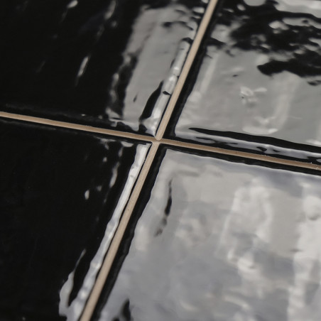 Glänzend schwarze Keramikfliesen reflektieren das Licht und sorgen für eine glatte Oberfläche. Die Fugenlinien bilden im Innenbe