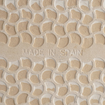 Azulejo cerâmico em relevo com pequenos padrões elevados em forma de crescente. As palavras `MADE IN SPAIN` estão inscritas cent