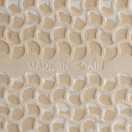 Keramische tegels in reliëf met kleine, halvemaanvormige reliëfpatronen. De woorden `MADE IN SPAIN` zijn centraal gegraveerd, wa