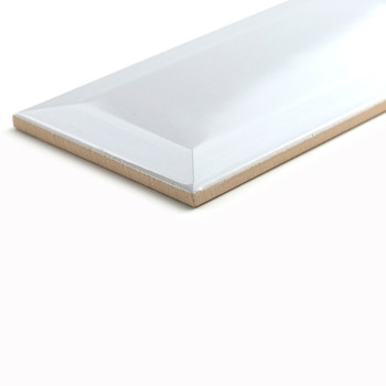 Un azulejo cerámico rectangular descansa sobre una superficie blanca, mostrando un acabado brillante con bordes biselados, refle