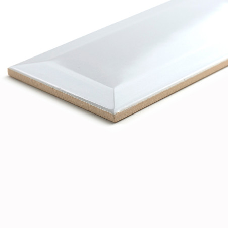 Un azulejo cerámico rectangular descansa sobre una superficie blanca, mostrando un acabado brillante con bordes biselados, refle