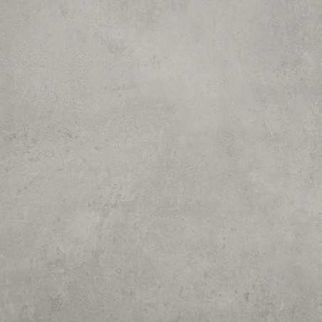 Un carreau gris clair à texture lisse repose à plat, présentant de légères mouchetures et de subtiles variations de tons, suggér