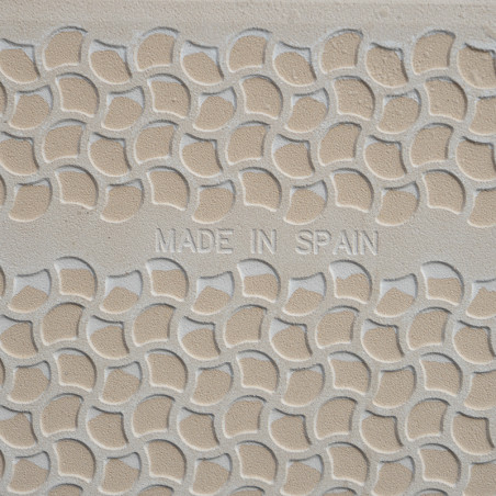 Een beige tegel vertoont een verhoogd, halfrond patroon in een herhalend geometrisch ontwerp. De centrale tekst luidt: `MADE IN Een beige tegel vertoont een verhoogd, halfrond patroon in een herhalend geometrisch ontwerp. De centrale tekst luidt: `MADE IN