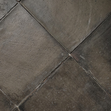 Terracottategels vormen een verweerd, aards patroon, met subtiele textuurvariaties, die strak in elkaar passen in een dicht moza