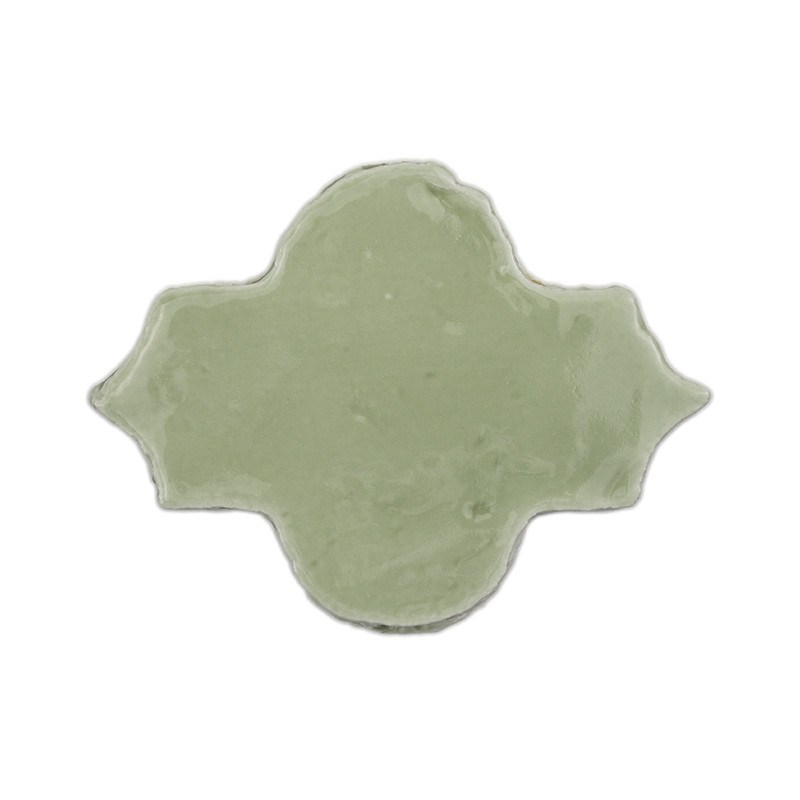A single, glossy, green terracotta tile features a decorative quatrefoil shape against a plain white background.