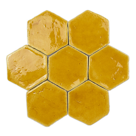 Carreaux hexagonaux en terre cuite, vernissés et brillants, disposés en nid d'abeille sur un fond blanc uni.
