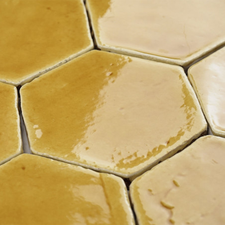 Los azulejos hexagonales de terracota con un acabado brillante se entrelazan, creando un patrón cálido y terroso en una disposic