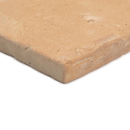 Les carreaux en terre cuite reposent sur une surface blanche, présentant un bord rugueux et naturel et une texture mate et terre