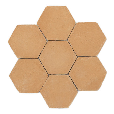 Los azulejos de terracota hexagonales están dispuestos en forma de panal sobre un fondo blanco liso.
