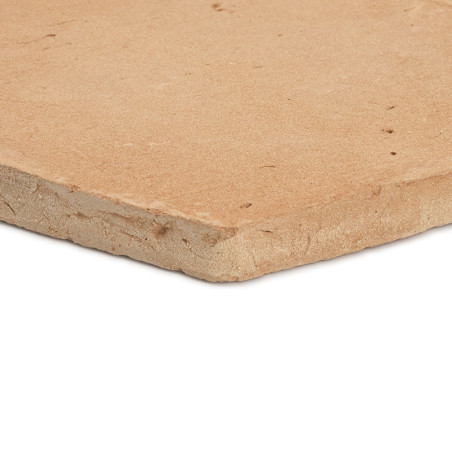 Les carreaux en terre cuite reposent à plat, présentant une surface rugueuse et texturée, avec des imperfections naturelles visi