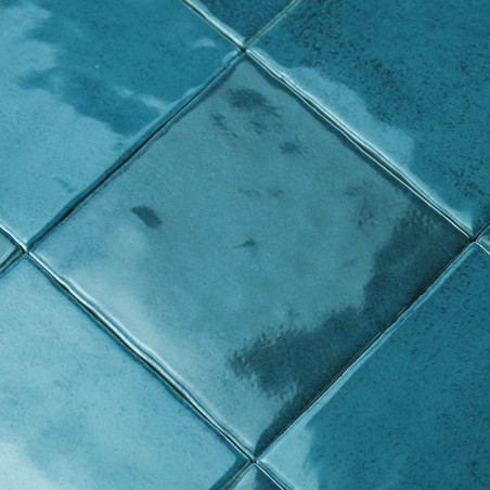 Les carreaux de céramique, émaillés dans des tons de bleu, reflètent la lumière dans une gamme d'éclats brillants, disposés en f Les carreaux de céramique, émaillés dans des tons de bleu, reflètent la lumière dans une gamme d'éclats brillants, disposés en f