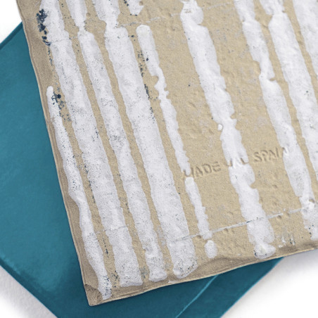 Deux carreaux superposés sont empilés, le carreau supérieur présentant des lignes verticales blanches sur une surface beige text Deux carreaux superposés sont empilés, le carreau supérieur présentant des lignes verticales blanches sur une surface beige text