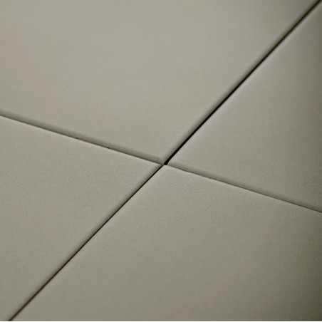 Quatre tuiles carrées et lisses se croisent en un point central. Ils forment un motif quadrillé de couleur beige neutre.